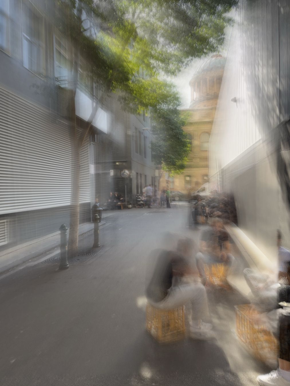 Photograph of laneway coffee shop in Melbourne. Exposure time is nine seconds, so the people are all blurred by their movement.