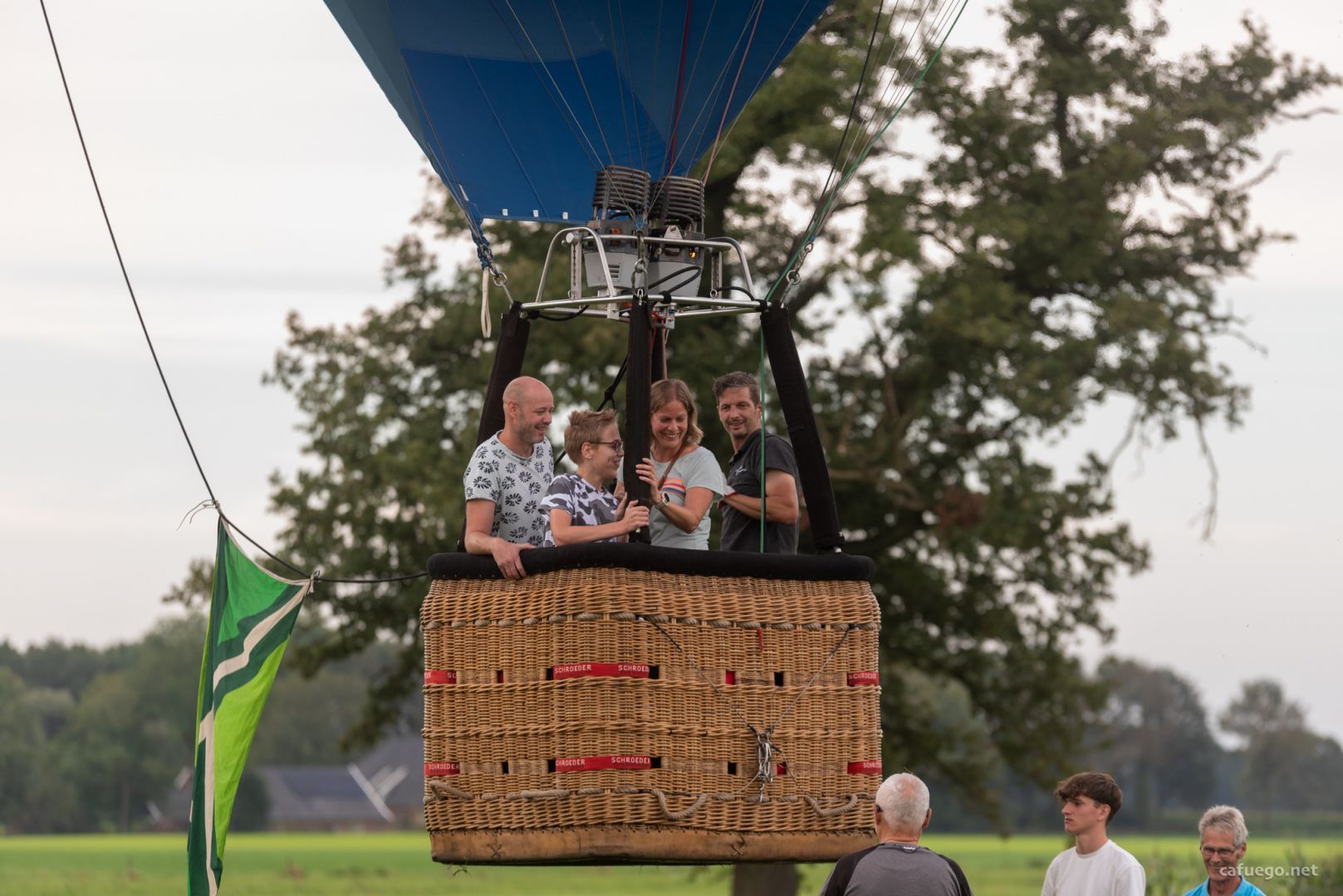 Balloon basket with people in it drifting upward, already at head height.