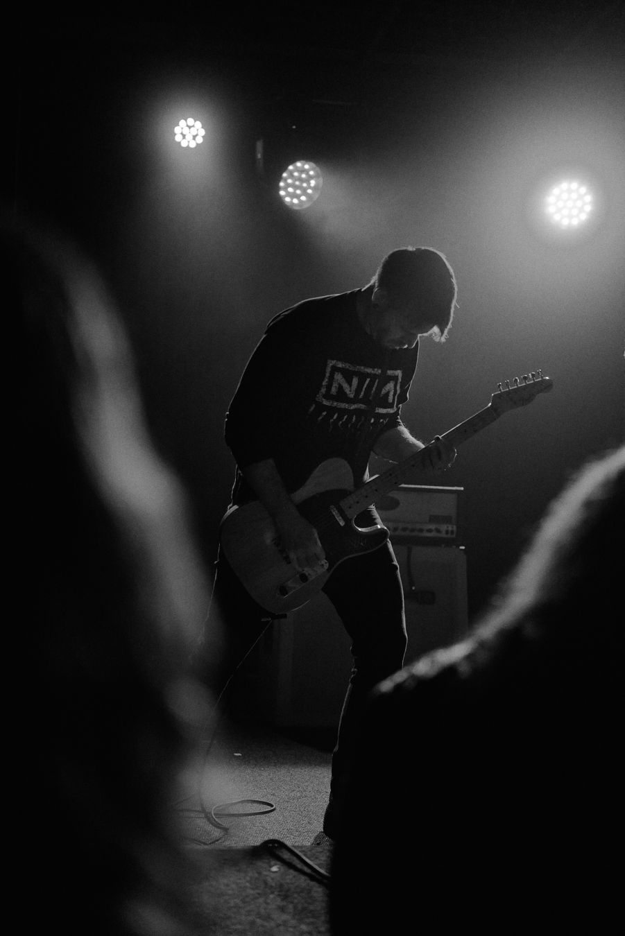slowcuts guitarist with a few crowd members framing him.