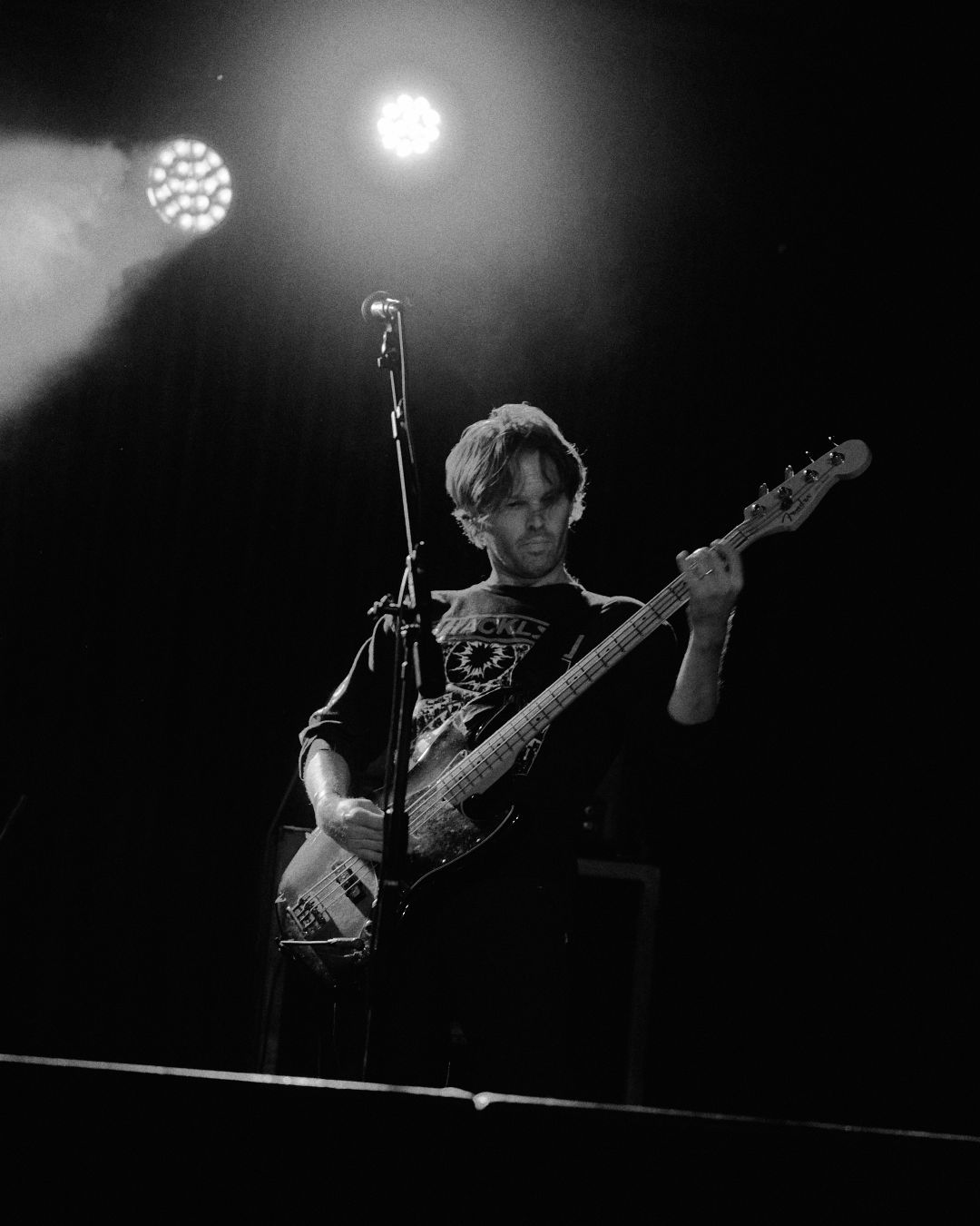 Black and white image of Resin Tomb's bassist locking in on the riff.