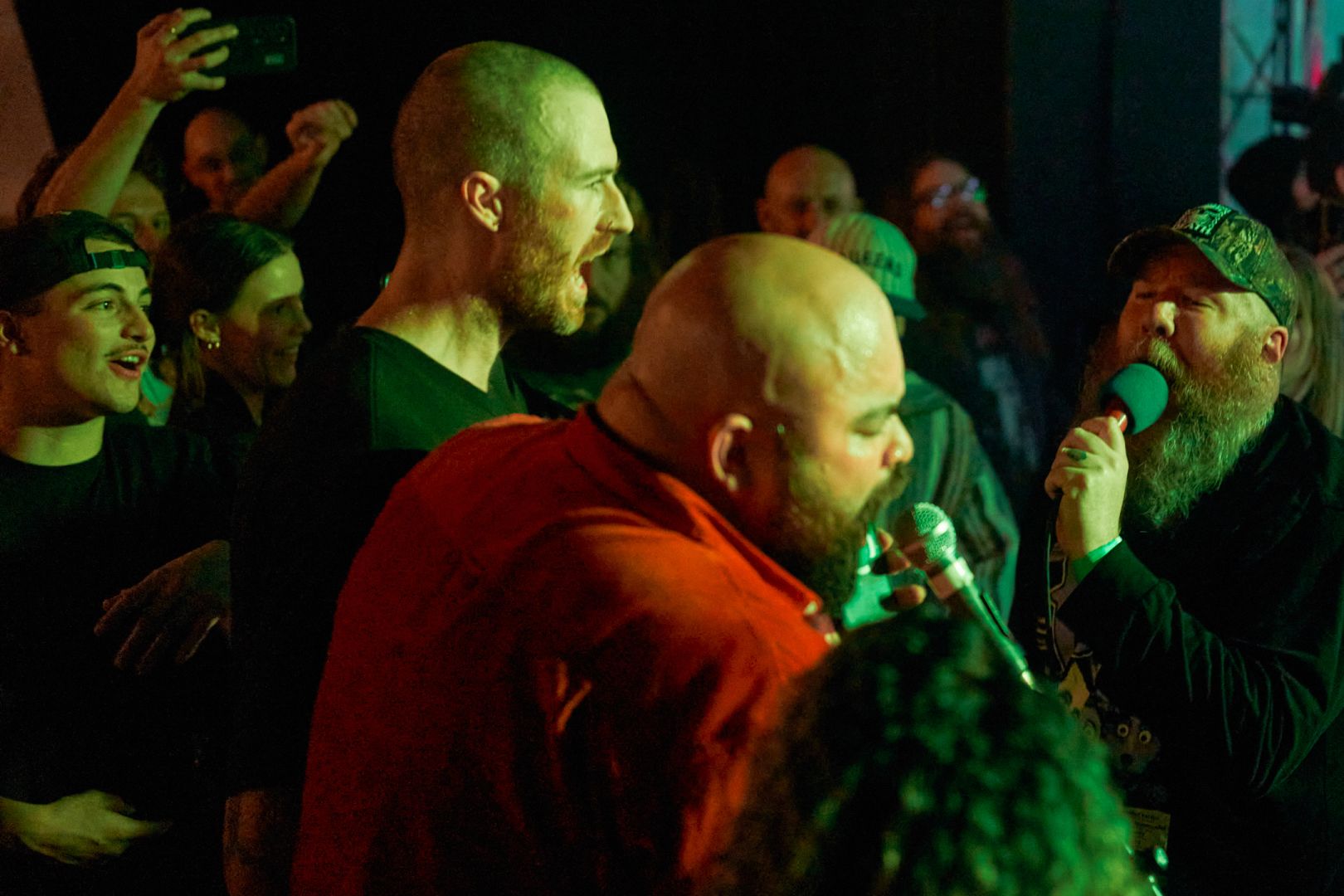 The vocalist is in the crowd. An extra mix has been brought into the crowd for singalongs. Many smiling faces from the crowd watch on.