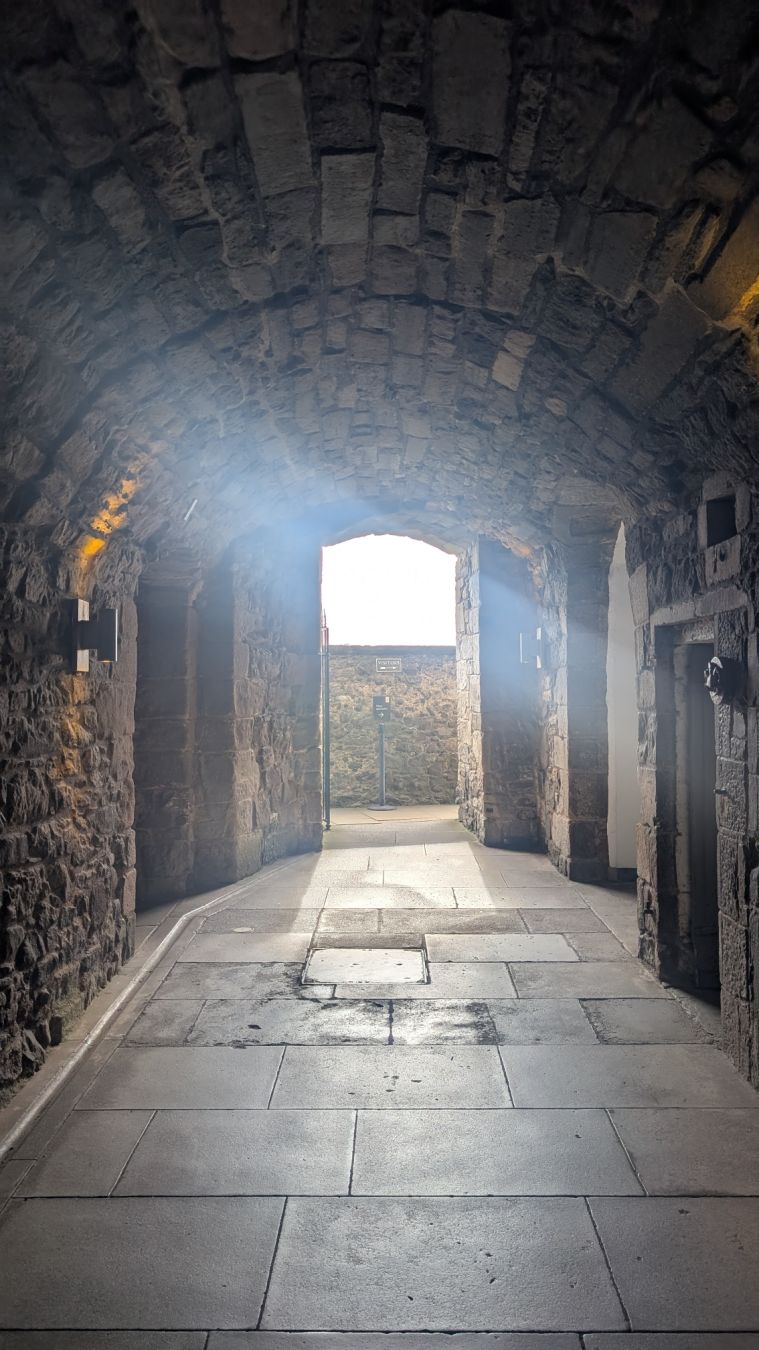 Light streaming through a stone vaulted corridor