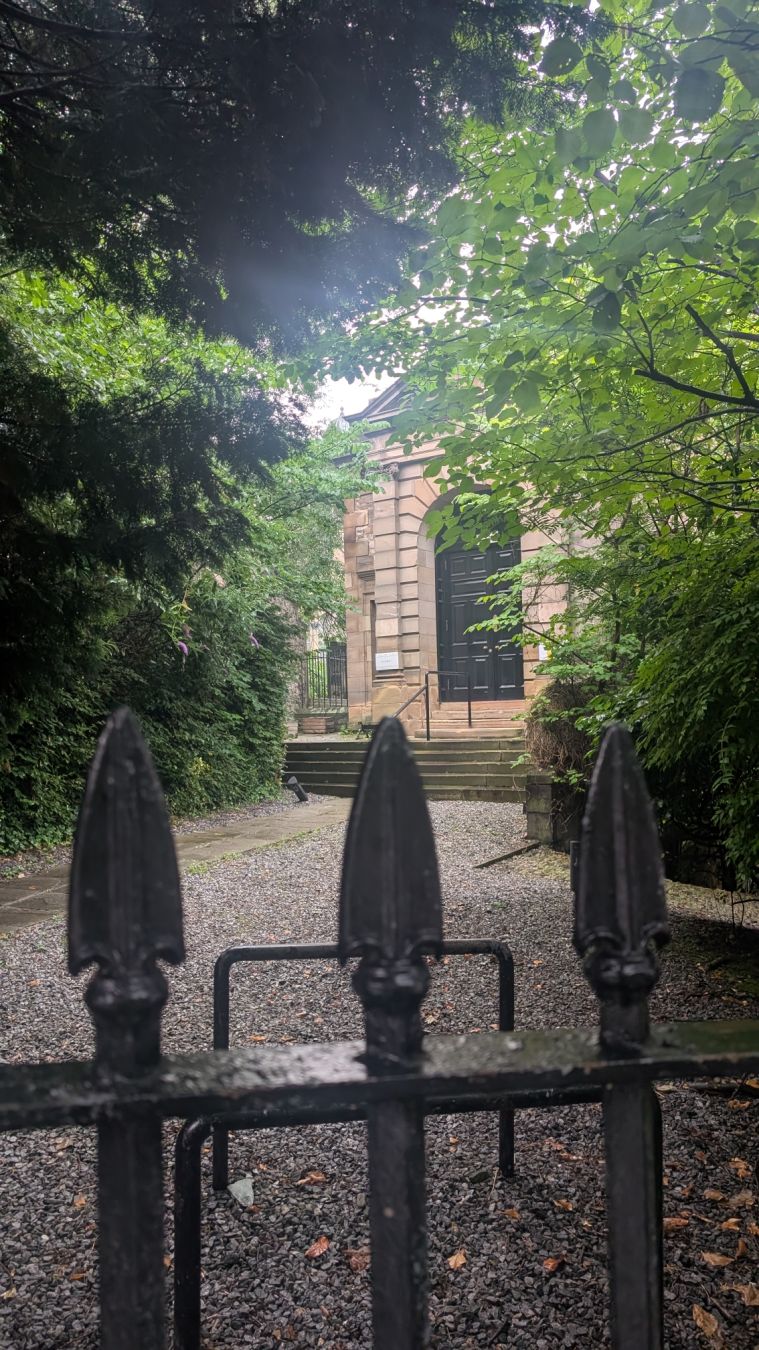 Wrought iron and a lovely building with trees everywhere. Unfortunately there was a planning application to remove all the trees and bushes on the left to save the stone boundary wall.