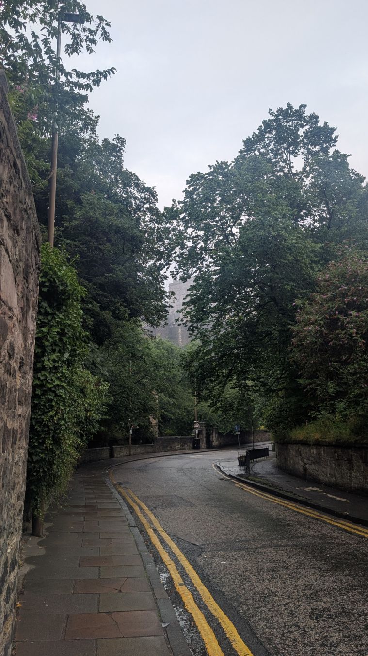 The Edinburgh castle from below, just barely visible through the low clouds.