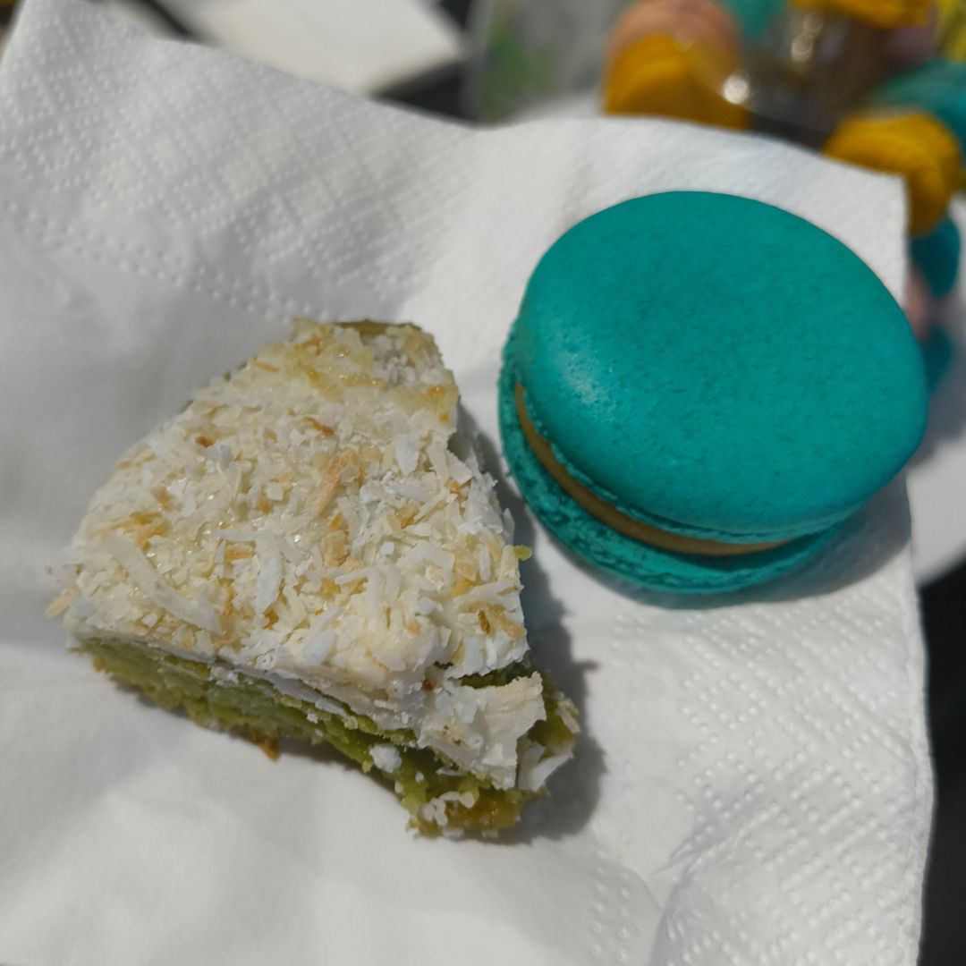 A slice of a coconut and pandan cookie and a salted caramel macaron made by Thicc Cookies.
