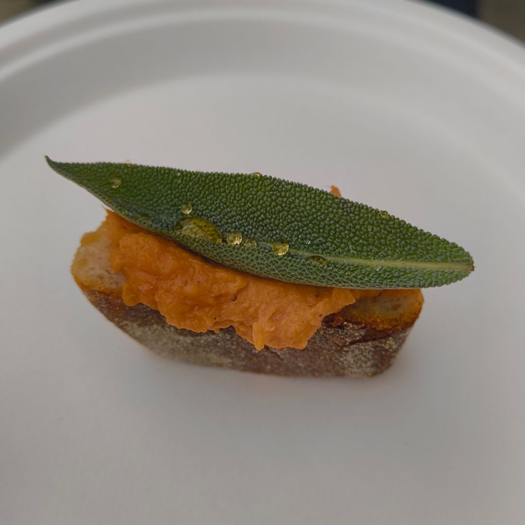 A vegan friendly canape made with sourdough bread, sweet potato puree and a sage leaf topped with red stringybark honey.