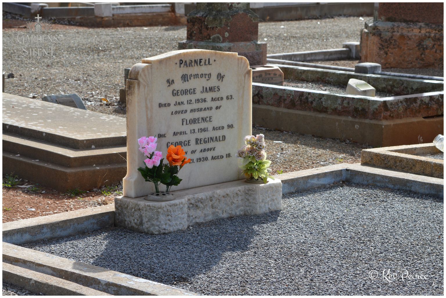 A selective colour photograph featuring the light toned granite headstone of the Parnell family, including George James, Florence, and George Reginald. Two small vases filled with bright pink, orange, and pale green artificial flowers provide vibrant colour against the neutral stone base and dark gravelled plot in the foreground.